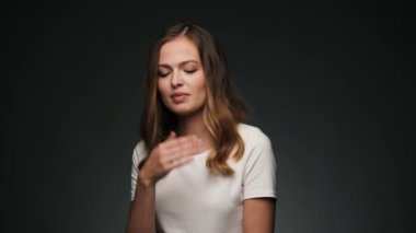 Bir öpücük üfleme ve gülümseyen genç güzel beyaz bir kadın portresi.