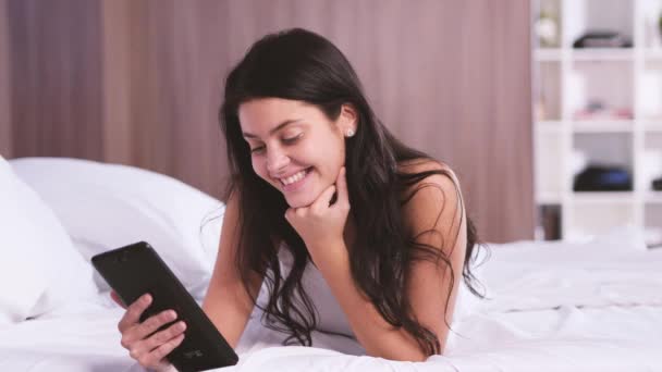매력적인 젊은 여자 집에서. 그녀의 tablet pc에서 메신저를 사용 하 여 웃 고 — 비디오