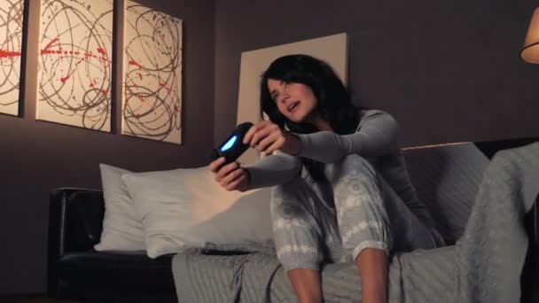 Frau spielt Videospiel auf Konsole und gewinnt. Zuhause auf dem Sofa sitzen — Stockvideo