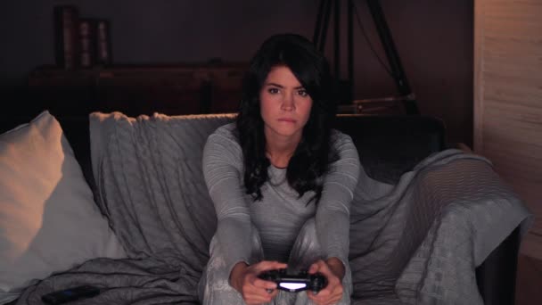 Kvinna som spelar TV-spel på konsolen och vinner. Sitter på soffan hemma — Stockvideo