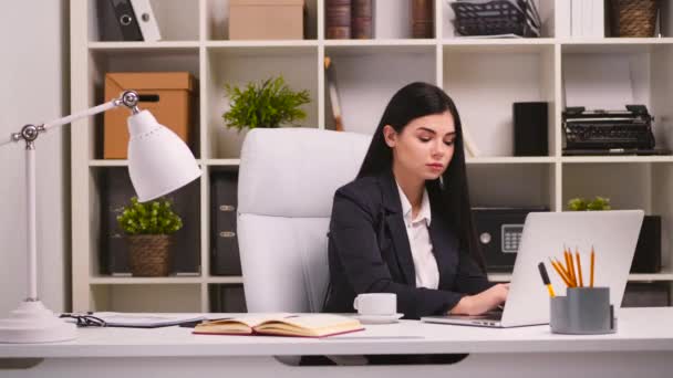 Pretty businesswoman in her office. — Stock Video