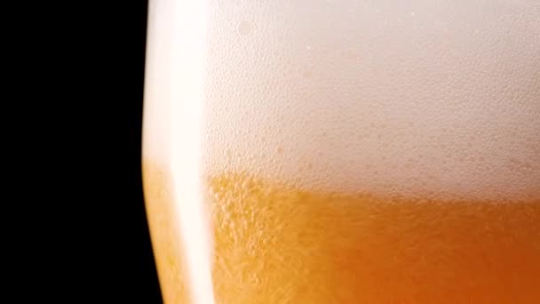 Birra leggera versata nel bicchiere. Con bolle e schiuma. — Video Stock