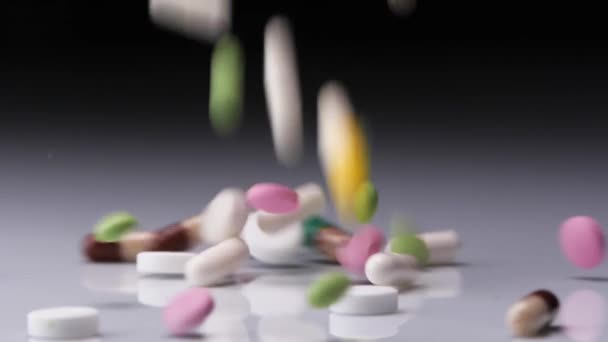 Барвисті таблетки падають вниз — стокове відео