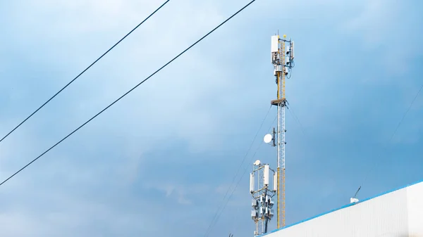 Cellular phone antennas on a building roof. — Stock Photo, Image