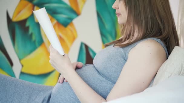 Mujer embarazada leyendo — Vídeo de stock