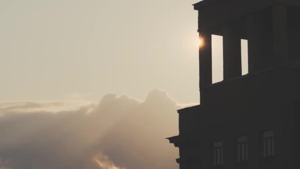 구름낀 일출 하늘을 배경으로 건축하는 모습 — 비디오