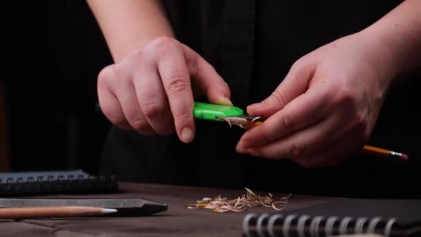 Художник обрізає точильний олівець над столом — стокове відео