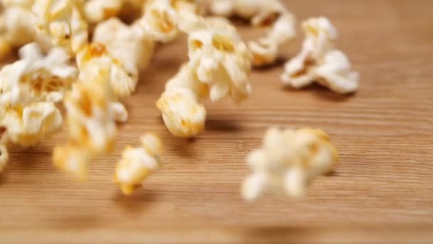 Palomitas de maíz derramadas en mesa de madera — Vídeos de Stock