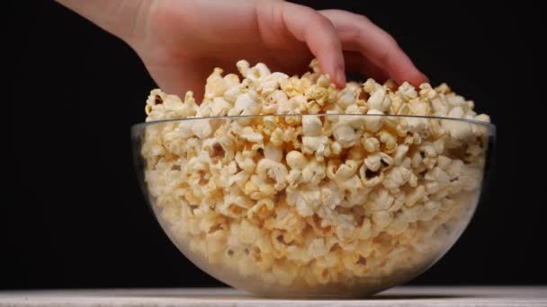 Oříznout člověka, který bere popcorn ze skleněné mísy — Stock video