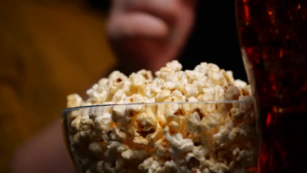 Анонимный человек ест попкорн и смотрит кино — стоковое видео