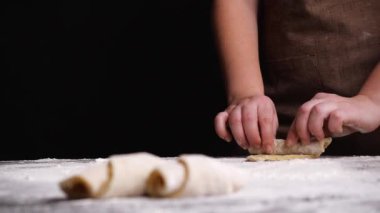 Ekin kadın masada hamur işi pişiriyor.