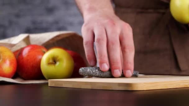 Crop chef cortando maçã com faca — Vídeo de Stock