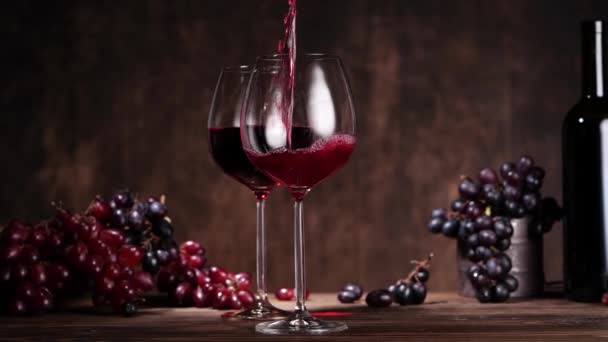 Red wine filling glass near grapes — Stock Video