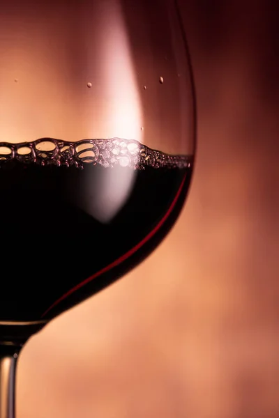 Kelch mit Rotwein auf glühendem Hintergrund — Stockfoto