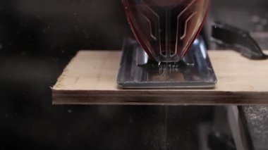 İsimsiz bir zanaatkar kontrplak kesiyor.