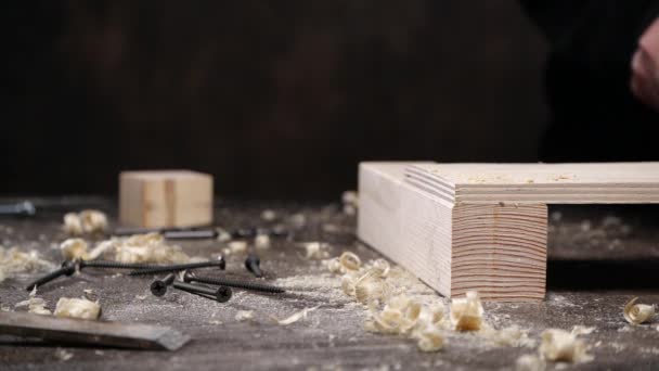 Анонимный плотник подметает деревянную доску — стоковое видео