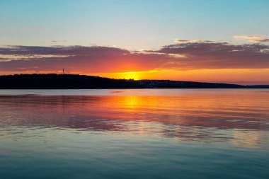 Büyük sakin göl kenarında muhteşem turuncu deniz mavisi günbatımı