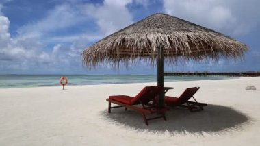 Ahşap şezlong ve şemsiye yaz günü, Maldivler tropik sahilde
