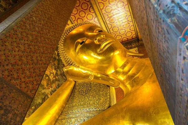 Giant Reclining Buddha inside Wat Pho Temple in Bangkok in a summer day