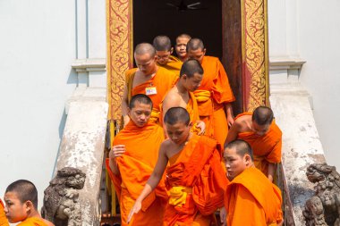 Chiang Mai, Tayland - 29 Mart 2018: Chiang Mai, Tayland Wat Phra Singh tapınağında bir yaz günü parlak turuncu elbiseler giyen Budistler rahipler