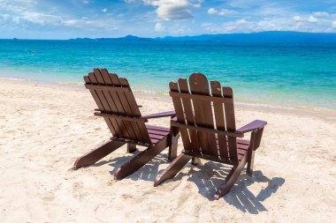 Koh Samui Adası, Tayland bir yaz günü kum plajındaki boş ahşap sandalye