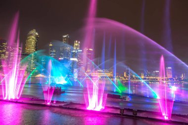 Singapur - 23 Haziran 2018: Çeşmeler gece lazer Singapur'da göster: Marina Bay Sands hotel yaz geceleri