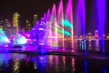 SINGAPORE - JUNE 23, 2018: Fountains night laser show in Singapore near Marina Bay Sands hotel at summer night clipart