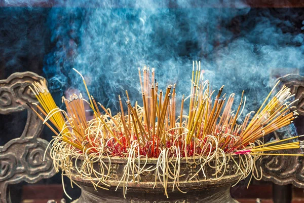 Burning incense sticks in Tran Quoc pagoda in Hanoi, Vietnam in a summer day