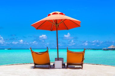 Maldivler - 24 Haziran 2018: Ahşap şezlong ve şemsiye yaz günü, Maldivler tropik sahilde