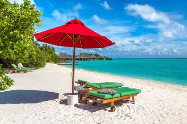 Maldivler - 24 Haziran 2018: Ahşap şezlong ve şemsiye yaz günü, Maldivler tropik sahilde