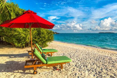 Maldivler - 24 Haziran 2018: Ahşap şezlong ve şemsiye yaz günü, Maldivler tropik sahilde