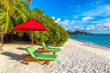 Maldivler - 24 Haziran 2018: Ahşap şezlong ve şemsiye yaz günü, Maldivler tropik sahilde