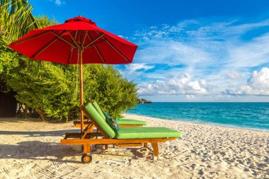 Maldivler - 24 Haziran 2018: Ahşap şezlong ve şemsiye yaz günü, Maldivler tropik sahilde