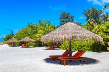 Maldivler - 24 Haziran 2018: Ahşap şezlong ve şemsiye yaz günü, Maldivler tropik sahilde