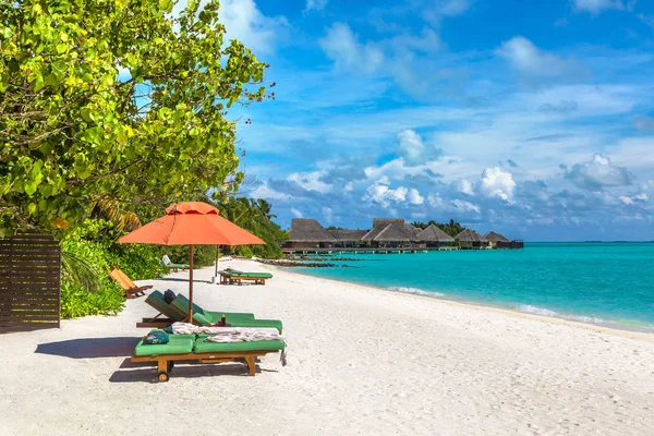 Maldivler - 24 Haziran 2018: Ahşap şezlong ve şemsiye yaz günü, Maldivler tropik sahilde