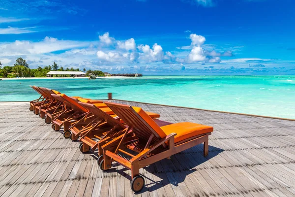 Maldivler - 24 Haziran 2018: Tropikal plaj yaz günü, Maldivler ahşap şezlong
