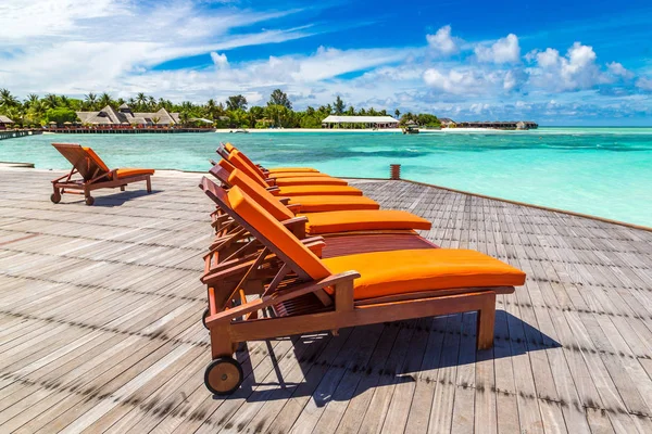 Maldivler - 24 Haziran 2018: Tropikal plaj yaz günü, Maldivler ahşap şezlong