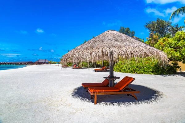 Maldivler - 24 Haziran 2018: Ahşap şezlong ve şemsiye yaz günü, Maldivler tropik sahilde