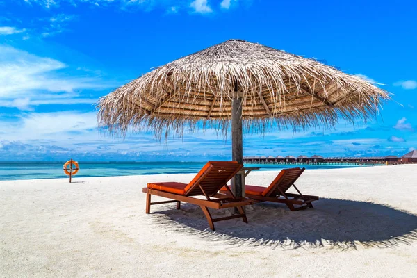 Maldivler - 24 Haziran 2018: Ahşap şezlong ve şemsiye yaz günü, Maldivler tropik sahilde
