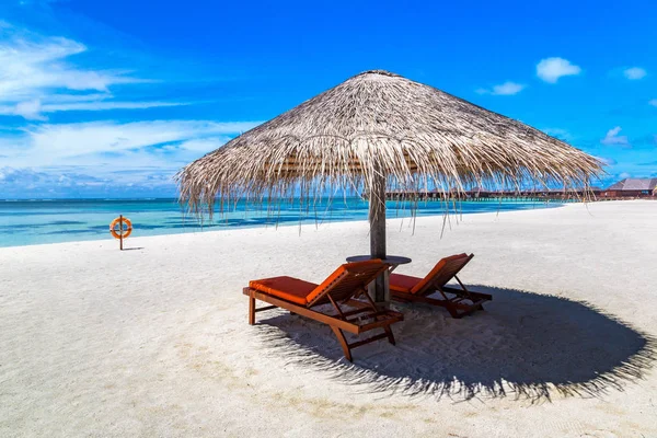 Maldivler - 24 Haziran 2018: Ahşap şezlong ve şemsiye yaz günü, Maldivler tropik sahilde