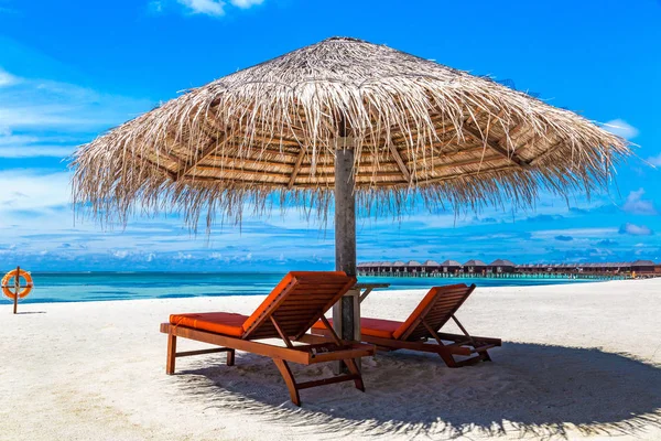 Maldivler - 24 Haziran 2018: Ahşap şezlong ve şemsiye yaz günü, Maldivler tropik sahilde