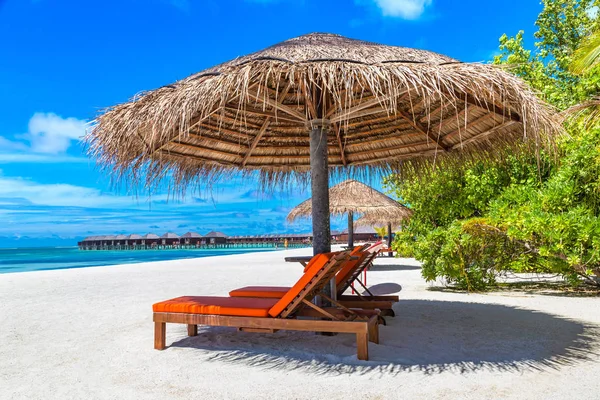 Maldivler - 24 Haziran 2018: Ahşap şezlong ve şemsiye yaz günü, Maldivler tropik sahilde