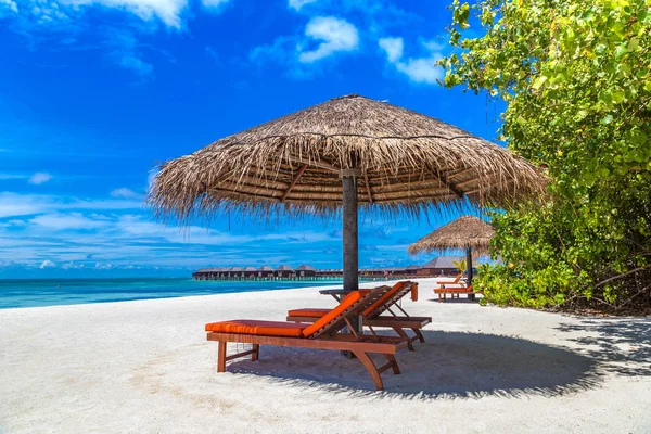 Maldivler - 24 Haziran 2018: Ahşap şezlong ve şemsiye yaz günü, Maldivler tropik sahilde