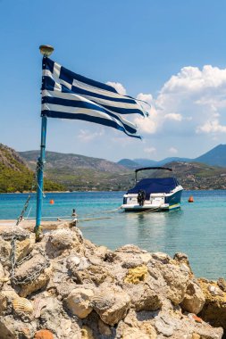 Loutraki, Yunanistan - 19 Temmuz 2015: Vouliagmeni Gölü ve Yunan bayrağı Loutraki yakınlarında bir yaz günü, Yunanistan
