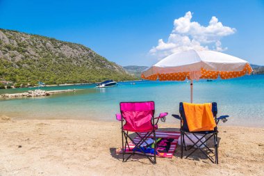 Loutraki, Yunanistan - 19 Temmuz 2015: Şemsiye ve sundecks Loutraki yakınlarında kumlu plajda bir yaz günü, Yunanistan