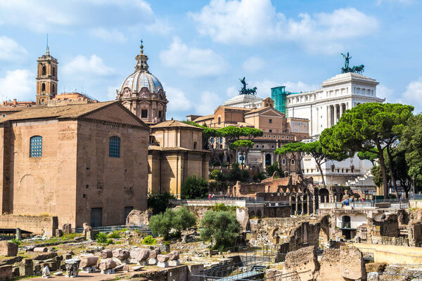 ROME, ITALY - JULY 12, 2014: Ancient ruins of Forum and Victor Emmanuel II monument in a summer day in Rome, Italy