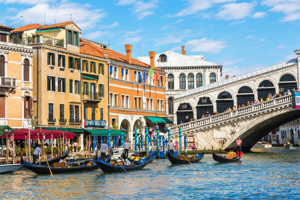 VENICE, ITALY - JUNE 18, 2014: Gondola at the Rialto bridge in Venice, in a beautiful summer day in Italy on June 18