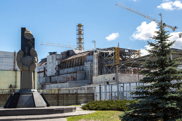 ЧЕРНОБИЛ, Украина - 26 апреля 2016 года: Чернобыльская АЭС и памятник в память о катастрофе, Украина в летний день

