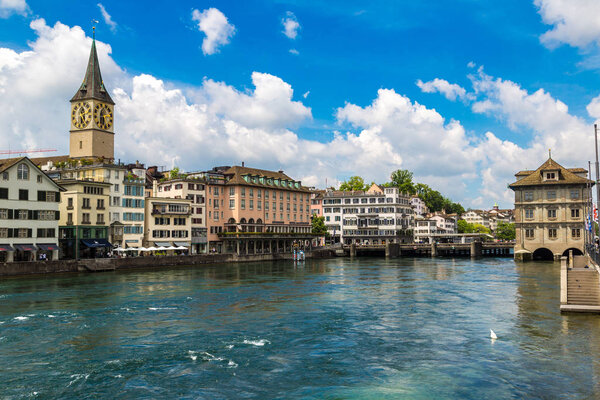 ZURICH, SWITZERLAND - JUNE 27, 2016: Clock tower in historical part of Zurich in a beautiful summer day, Switzerland