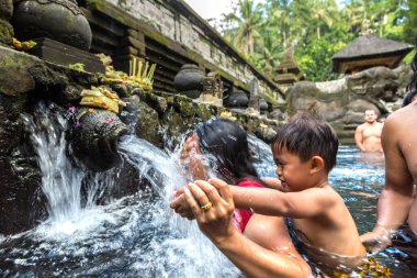 BALI, INDONEZYA - 28 Şubat 2020: Bali halkı Endonezya 'nın Bali kentindeki Pura Tirta Empul Tapınağı' ndaki kutsal havuzda dua ediyor